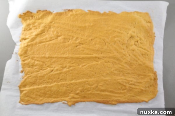 how to bake a Russian Honey cake A baked golden-brown Russian honey cake layer, fresh from the oven, showing its perfect thinness and caramelization, ready to be cooled