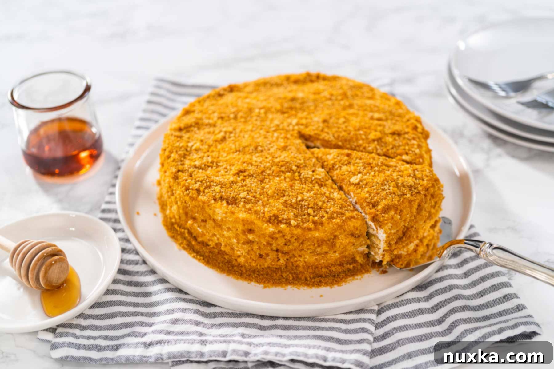 Medovik cake (Russian honey Cake) on a cake plate, showcasing its beautiful layers and crumb topping