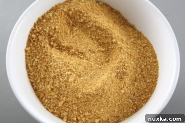 how to crush crumbs for a layered honey cake A bowl filled with finely crushed honey cake crumbs, ready to be used as a traditional garnish for the Medovik
