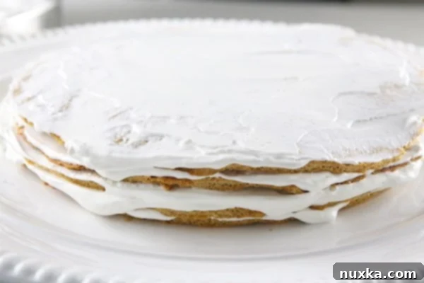 how to frost a Russian honey cake tutorial A Russian honey cake being frosted with a sour cream and whipped topping mixture, showcasing the smooth application