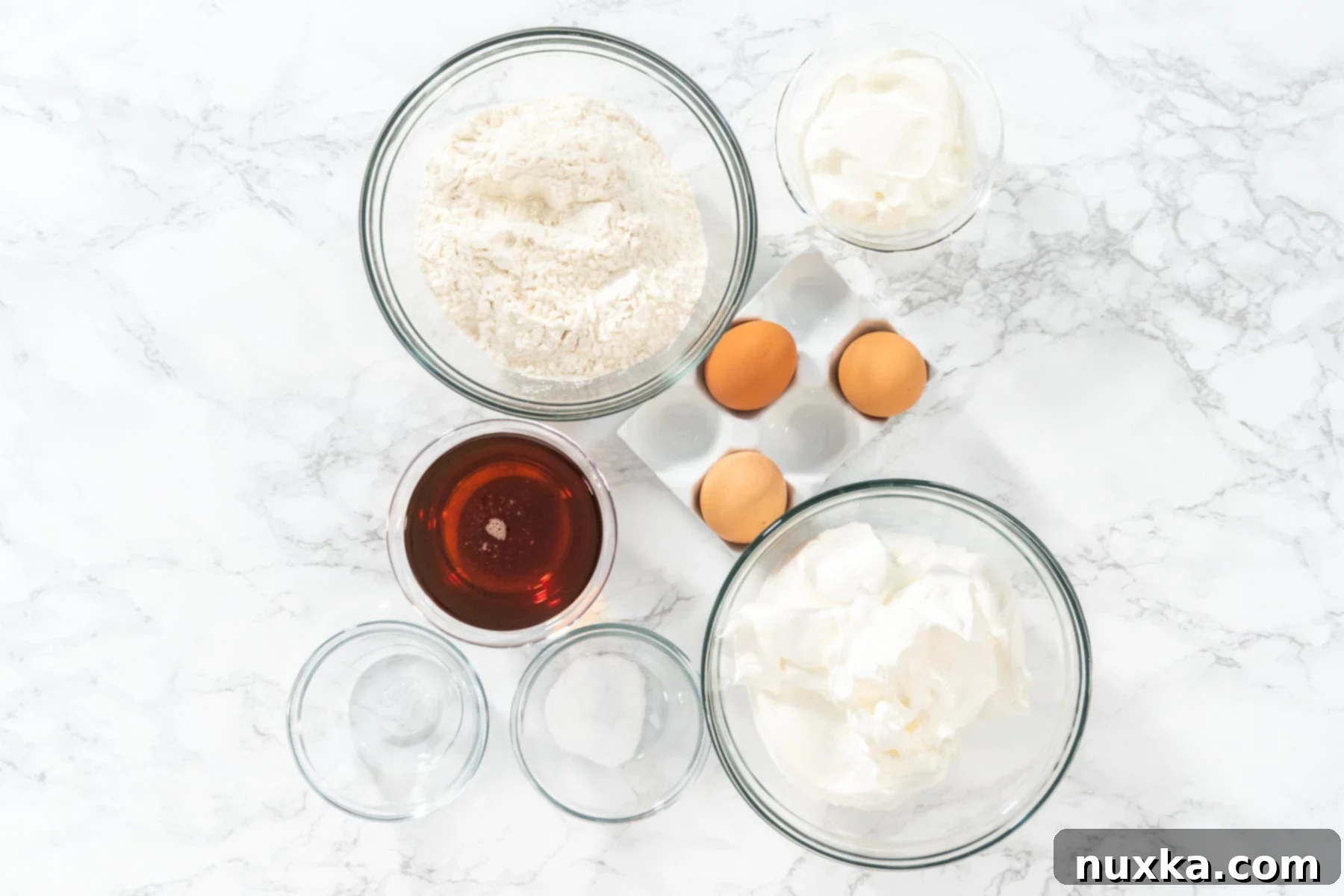 Ingredients for Honey Cake Medovik: honey, eggs, flour, baking soda, vinegar, sour cream, and cool whip laid out on a table