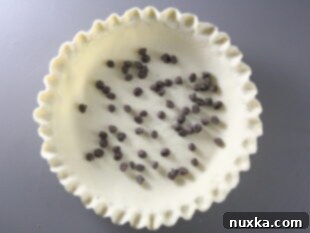 pie crust for Pecan Pie with chocolate chips sprinkled in the base