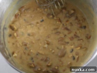 pecan pie filling with melted butter and chocolate chips, ready to be poured