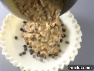 pecan pie batter being poured into a pie crust in a pie pan