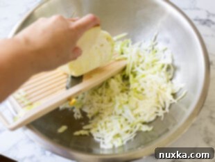 shredding cabbage with a Mandoline for cabbage salad