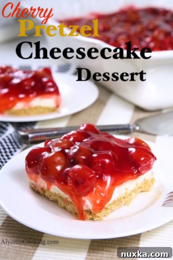 Overhead view of a Cherry Pretzel Cheesecake Dessert in a baking dish, garnished with fresh mint leaves.