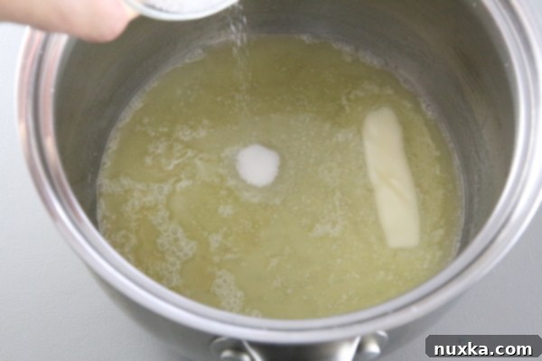 Melted butter in a saucepan, ready for crust ingredients.