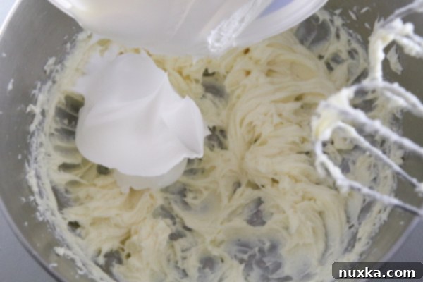 Beating softened cream cheese and sugar in a bowl until smooth and creamy.