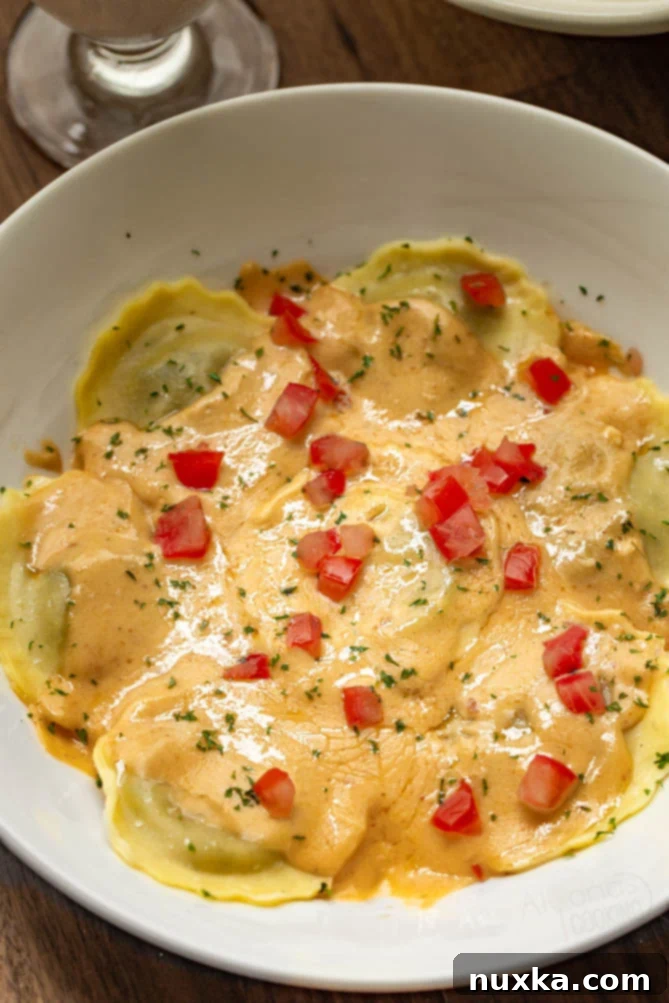 Olive Garden's mushroom ravioli copycat recipe placed on a serving plate garnished with diced tomatoes and dried parsley, ready to be enjoyed.
