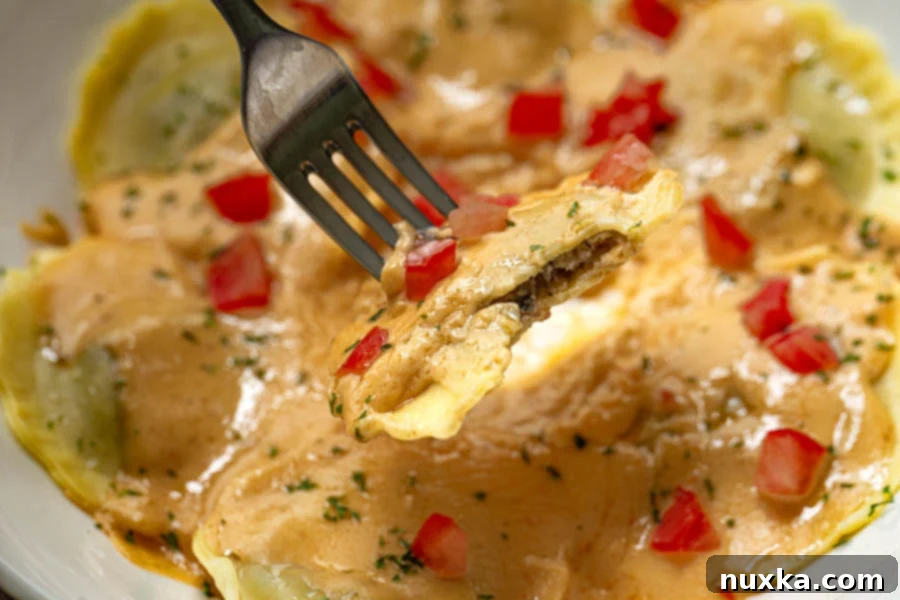 A fork taking a bite out of Olive Garden's mushroom ravioli copycat recipe, showing the creamy sauce and filling.