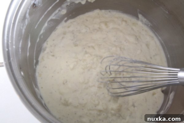 Whisking milk into the creamy soup mixture
