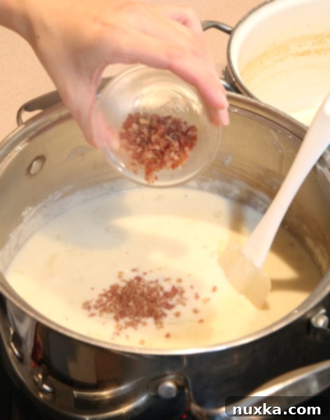 Garnishing baked potato soup with bacon bits and green onions