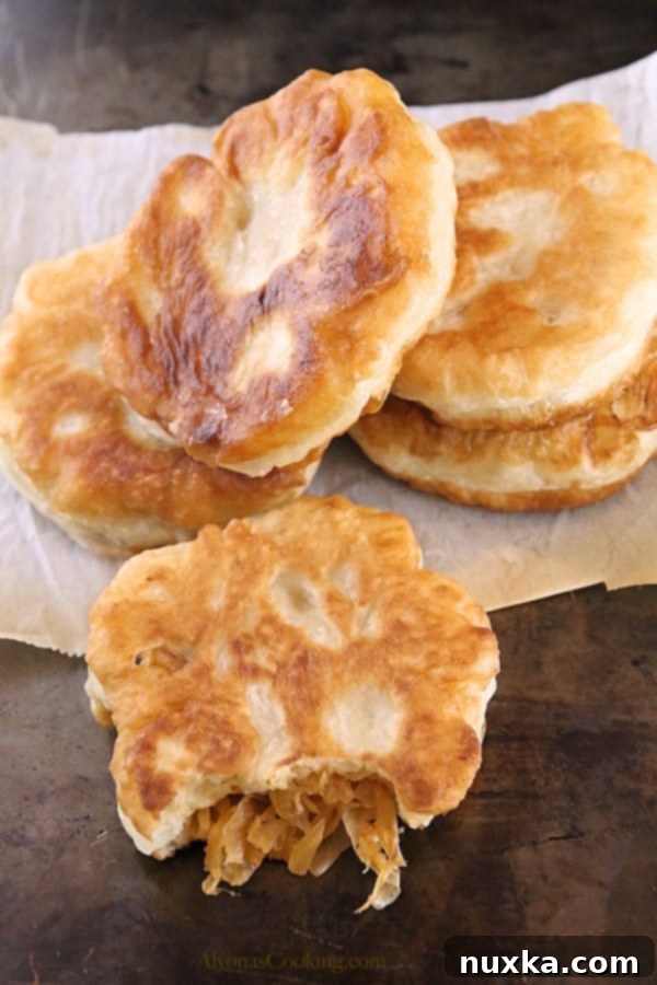 Shaping the homemade belyashi buns with a savory cabbage filling