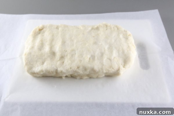 Rugelach dough formed into a precise rectangle, wrapped, and ready to chill in the refrigerator.
