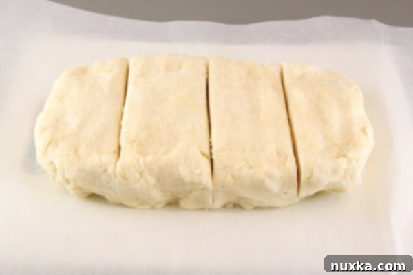 Chilled Rugelach dough, portioned into four pieces and ready to be rolled out for filling.