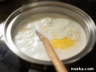 boiling rice and milk in a saucepan for baked rice pudding