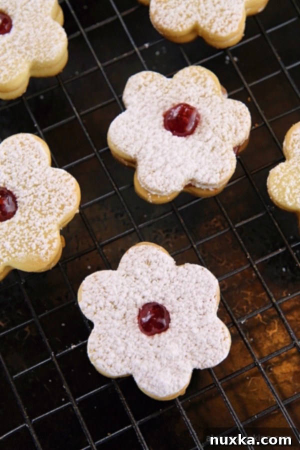 Stacked jam sandwich cookies with a cup of coffee
