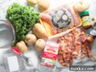 Detailed flat lay of all ingredients for Zuppa Toscana: fresh kale, a bowl of heavy cream, a small plate with cayenne pepper, chicken bouillon powder, salt, a glass of water, a whole onion, raw Italian pork sausage links, and garlic cloves.
