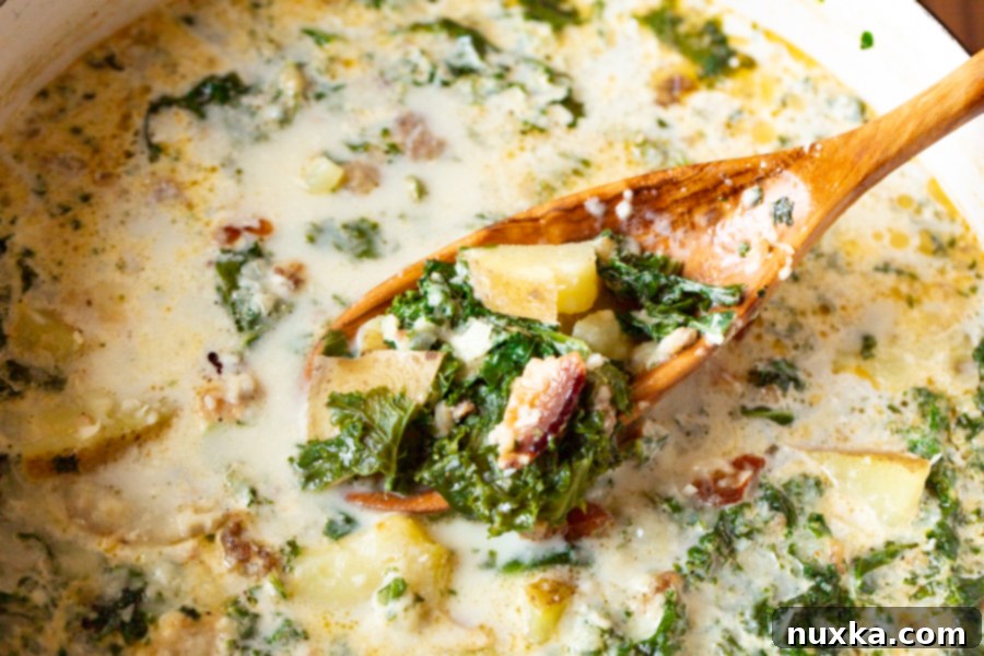 Close-up of a rustic Zuppa Toscana soup bowl, showcasing the rich blend of Italian sausage, fresh kale, crispy bacon, and creamy potatoes in a savory broth. A perfect hearty meal.