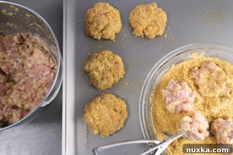 Chicken fritter mixture being formed into patties and coated with crumbs