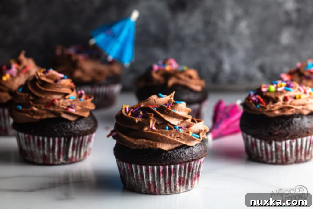 Delicious chocolate cupcakes decorated with festive sprinkles on a white platter, ready for a party