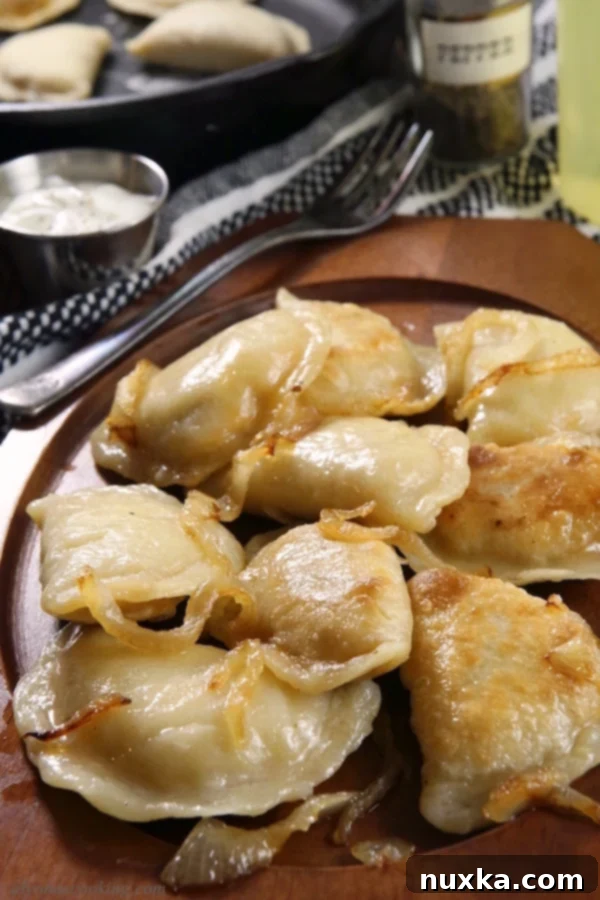 Delicious homemade Polish pierogi served with sour cream and herbs.