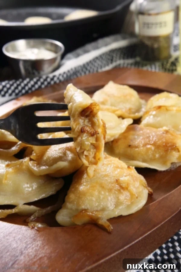 Uncooked homemade Polish pierogi showing the delicate dough and crimped edges.
