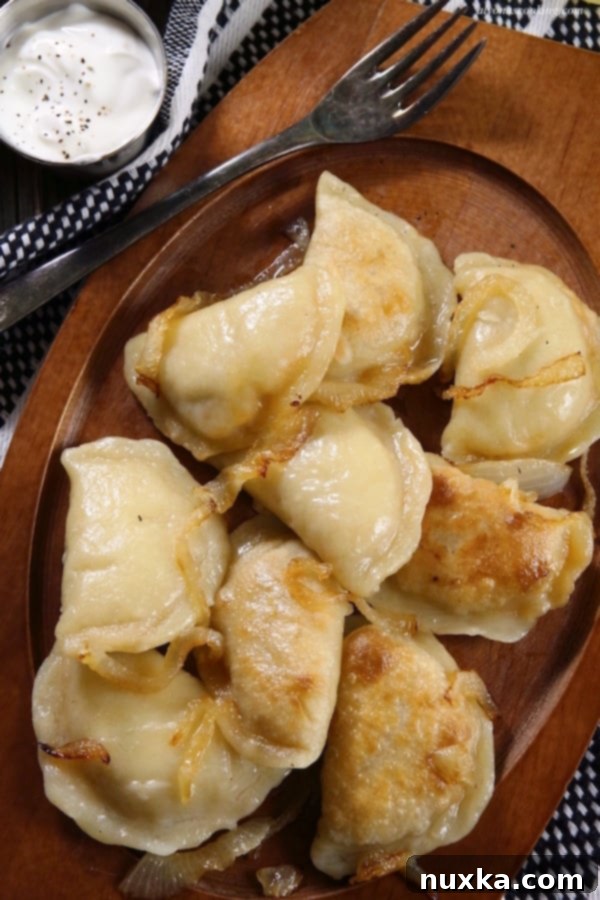A close-up view of freshly boiled and pan-fried homemade Polish pierogi, ready to serve.