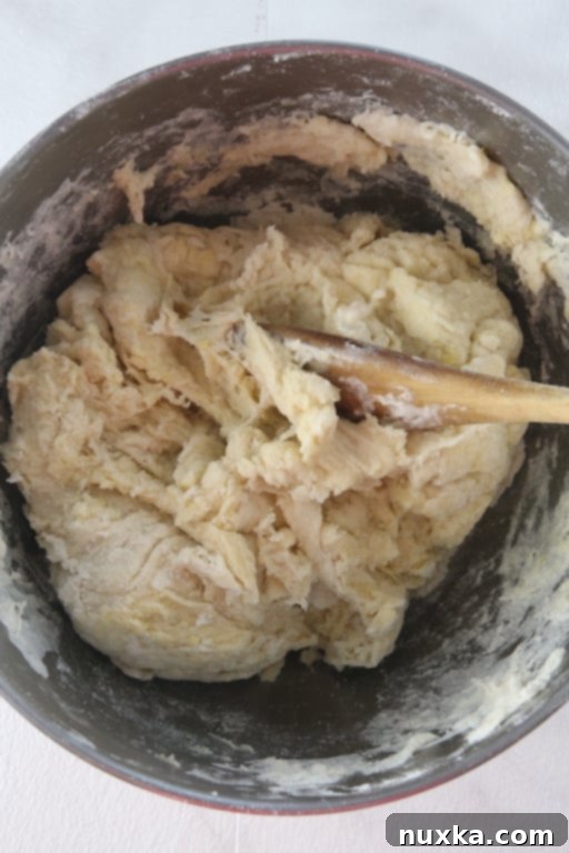 Close-up of pierogi dough being kneaded in a bowl.