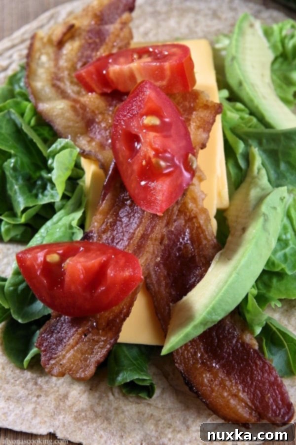 Assembling an Avocado Bacon Ranch Wrap with fresh ingredients and ranch