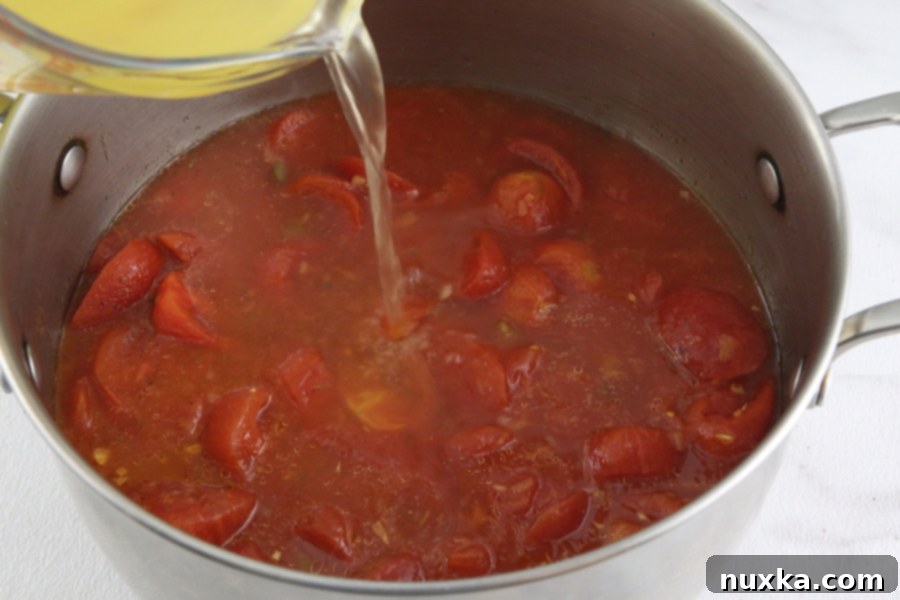 Close-up of the tomato soup bubbling gently during the simmering process