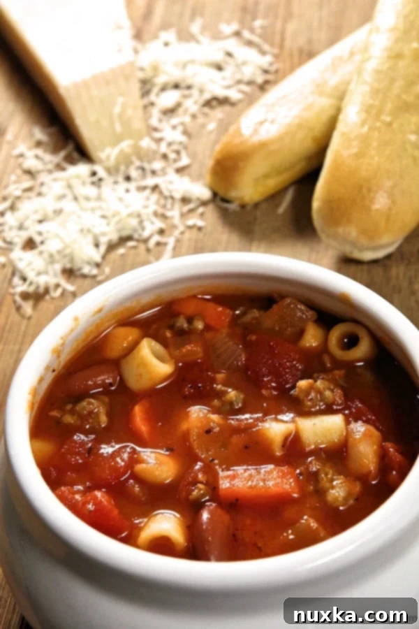 Close-up of a bowl of Olive Garden copycat Pasta Fagioli soup, garnished with parmesan