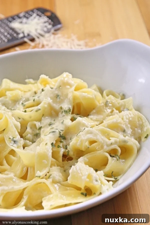 Close-up of creamy one-pot alfredo pasta with a fork, showing its rich texture.