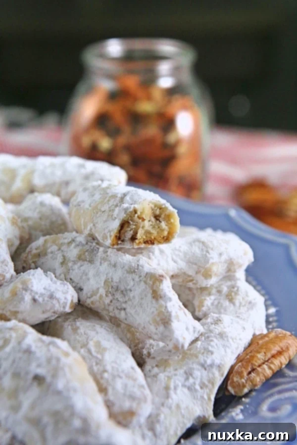Crunchy Nutty Fingers cookies, also known as Snowball cookies or Russian Tea cookies, coated in powdered sugar, ready to be enjoyed.