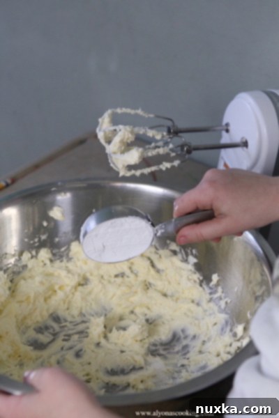 Close up of Nutty Fingers cookie dough being rolled into finger shapes on a clean surface.
