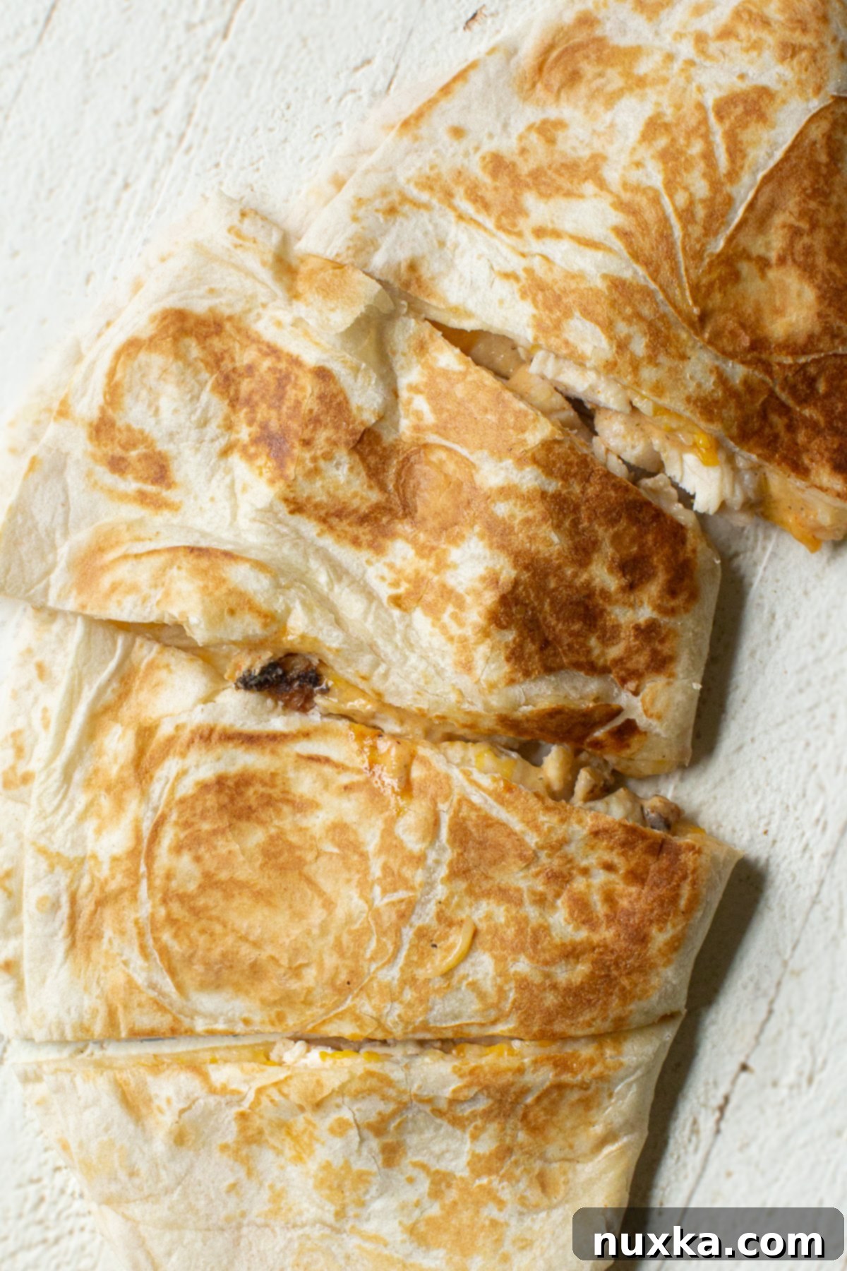 A vibrant and appetizing shot of a Taco Bell Chicken quesadilla, neatly cut into wedges and presented for serving.