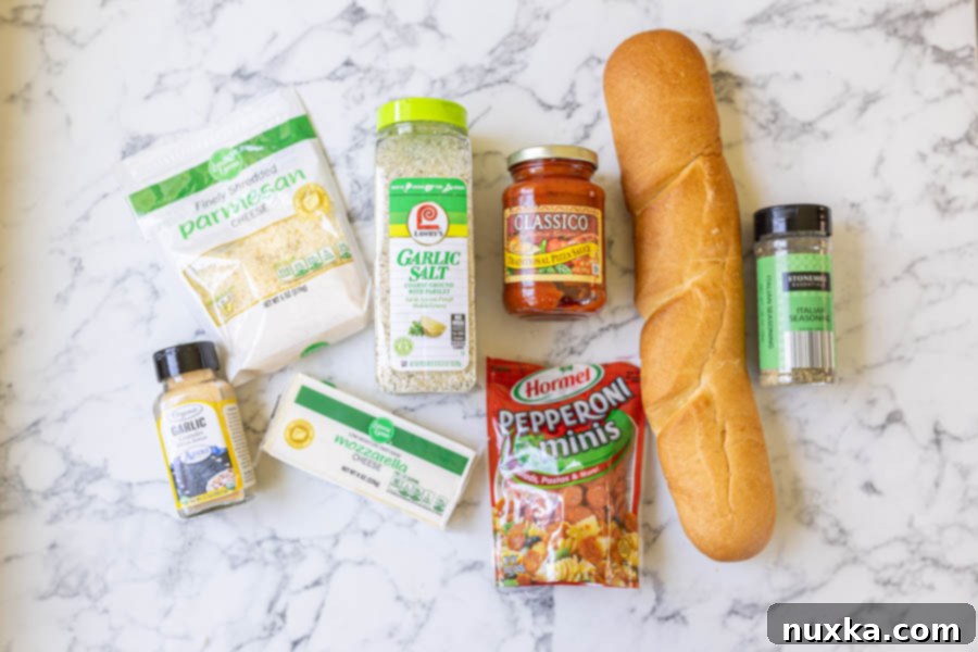 Ingredients laid out for French bread pizza: French bread, marinara sauce, mozzarella, Parmesan, mini pepperonis, garlic powder, garlic salt, Italian seasoning