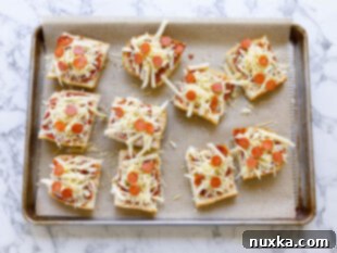 Applying marinara sauce, cheese, and pepperoni to sliced French bread pieces on a baking sheet