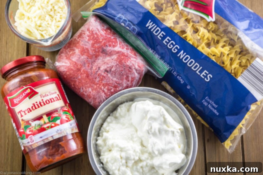 Ingredients laid out for One-Pan Beef Stroganoff, including ground beef, noodles, sour cream, and sauce