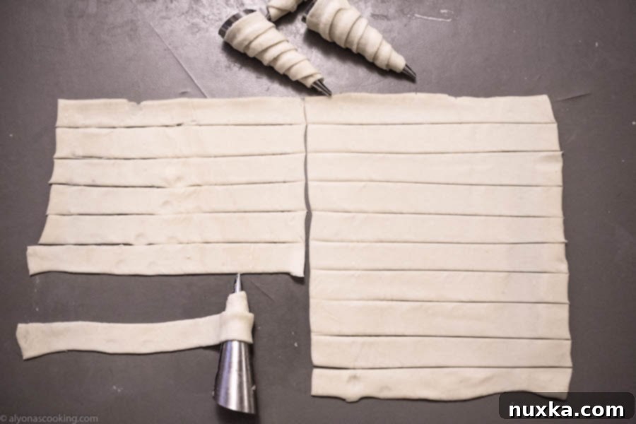 Puff pastry strips ready to be wrapped around cream horn molds