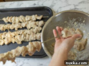 threading chicken on skewers