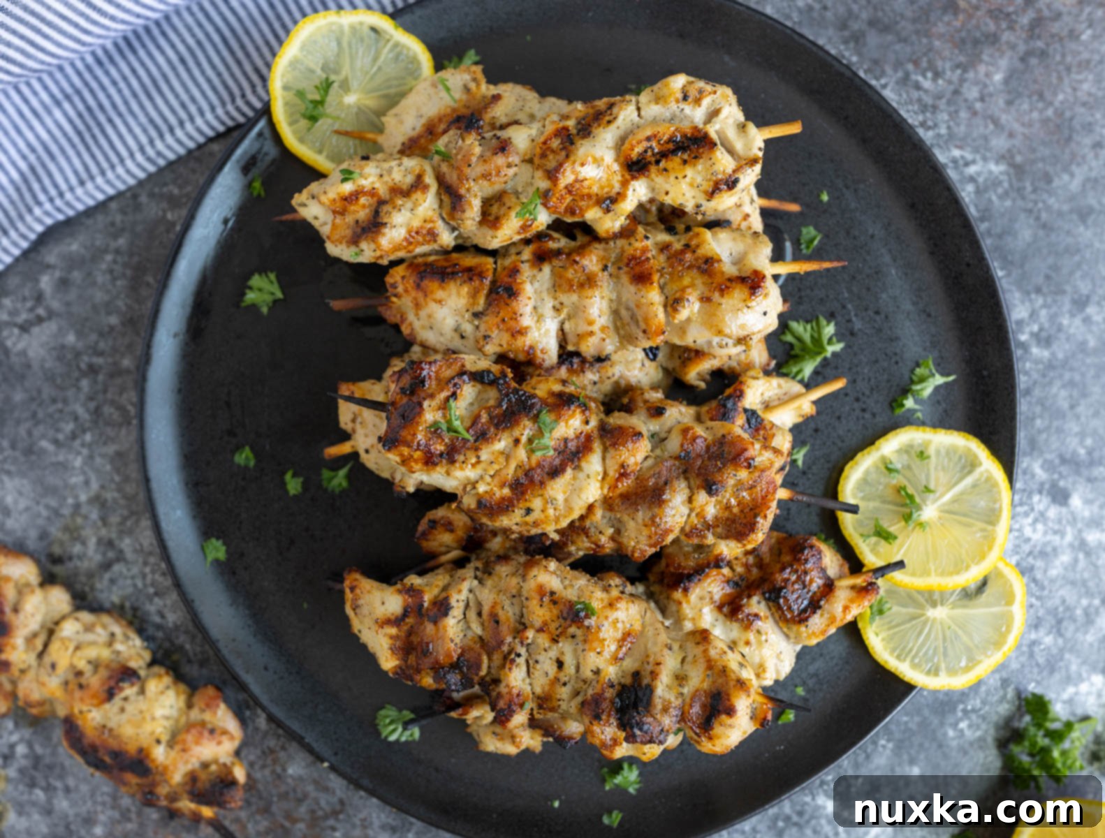 grilled chicken kabobs cooked on wooden skewers on a plate, ready to serve