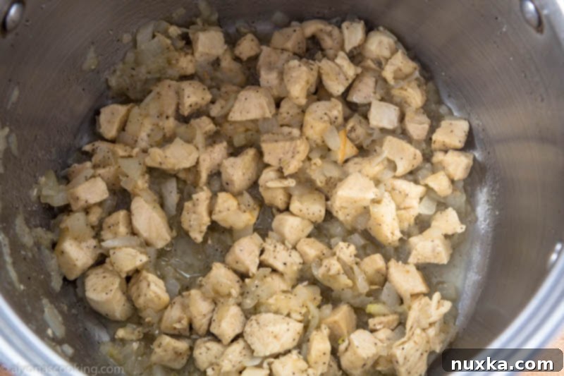 Sautéing chicken and onions in a pot for chicken and dumpling soup