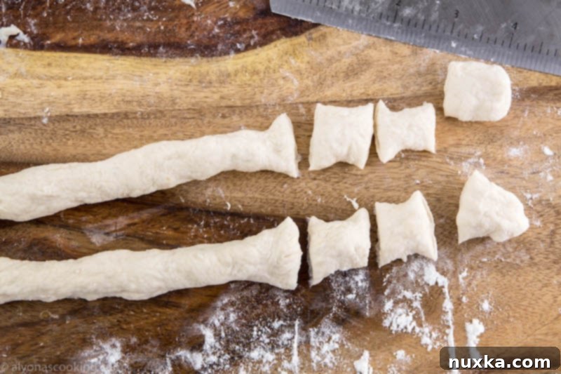 Cutting rolled dumpling dough into individual pieces