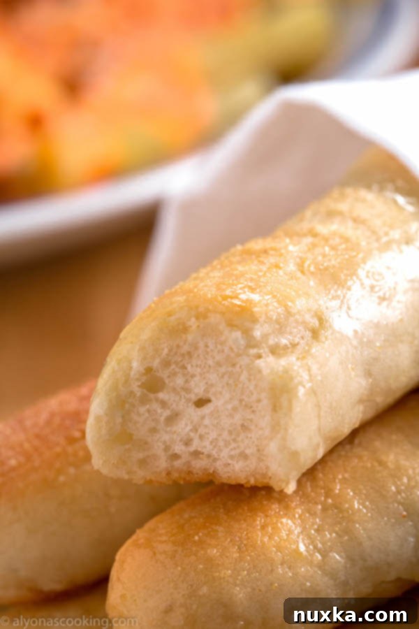Close-up of freshly baked Olive Garden style breadsticks, glistening with garlic butter