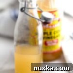 A close-up of a bottle of apple cider vinegar, ready to be used as a rice vinegar substitute.