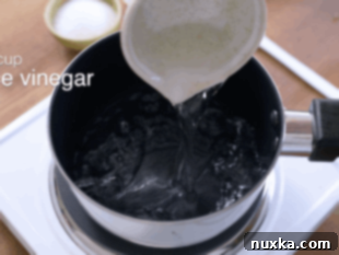 Heating rice vinegar, sugar, and salt to dissolve for sushi seasoning.