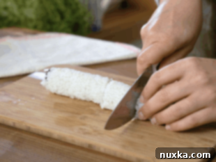 Slicing a Philadelphia roll into pieces
