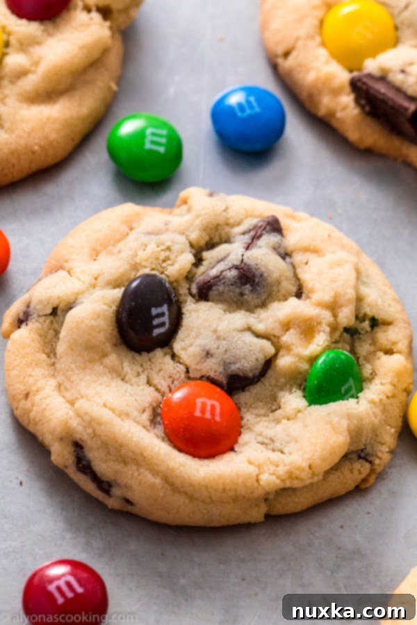 Closeup of freshly baked M&M cookies, showing the perfect spread and colorful candy pieces