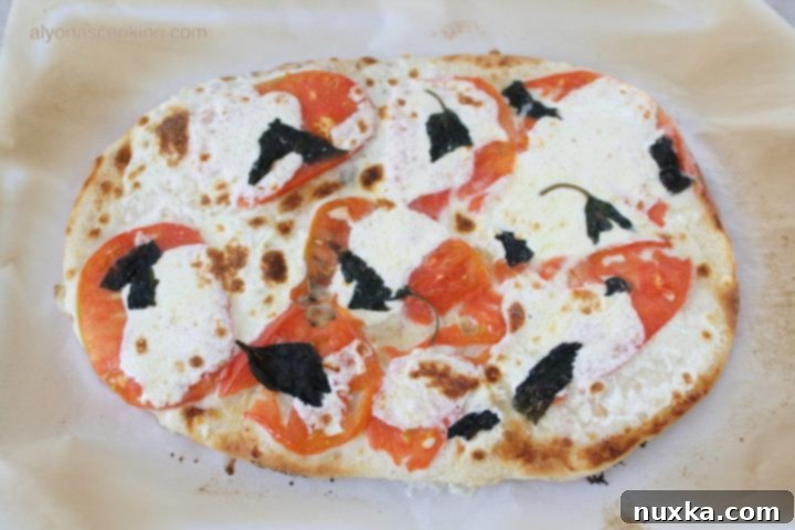 Delicious grilled white pizza with fresh mozzarella, tomatoes, and basil
